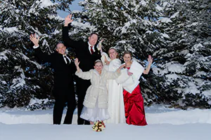 A wedding party take a fun pose in the snow