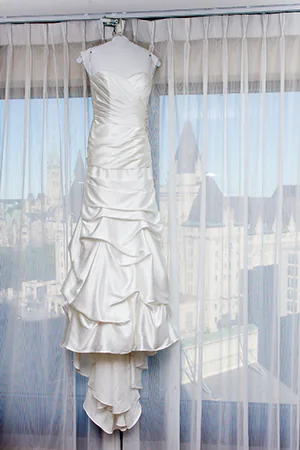 A wedding dress hangs in the window
