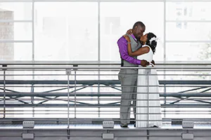 A bride and groom kiss over a pedway