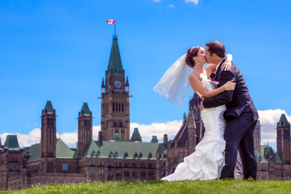 A bride and groom kiss overlooking Parliament Hill